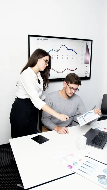 A team in an office reviewing financial charts and digital data on tablets.